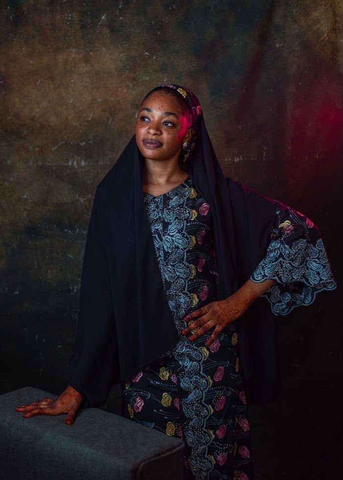 A striking portrait of an African woman wearing traditional cultural attire, standing confidently.
